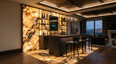 A modern home bar featuring Antico Onyx Travertine tiles as a dramatic focal point on the back wall and floor, showcasing a high-variation blend of honey gold, deep amber, and translucent cream tones with bold natural veining under warm ambient lighting.