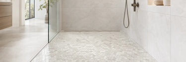 White marble hexagon mosaic tile on a walk-in shower floor