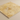 Close-up side angle showing the filled honed surface, straight edge, and thickness of an 18x18 gold yellow travertine tile