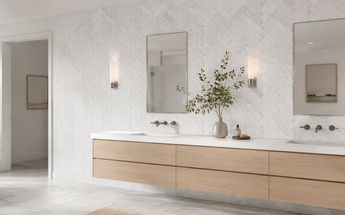 Bright contemporary bathroom featuring white Bianco Dolomite marble herringbone mosaics with delicate gray veining behind a floating oak vanity.