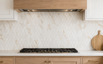 Calacatta Gold marble diamond mosaic tile installed as a backsplash in a bright contemporary kitchen.