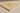 Close-up side angle showing the filled honed surface and straight edge of a 12x12 gold yellow travertine tile