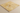 Close-up side angle showing the filled honed surface, straight edge, and thickness of an 18x18 gold yellow travertine tile