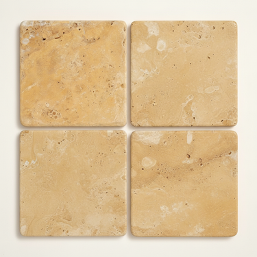 Four 6x6 tumbled gold yellow travertine tiles arranged in a 2x2 layout